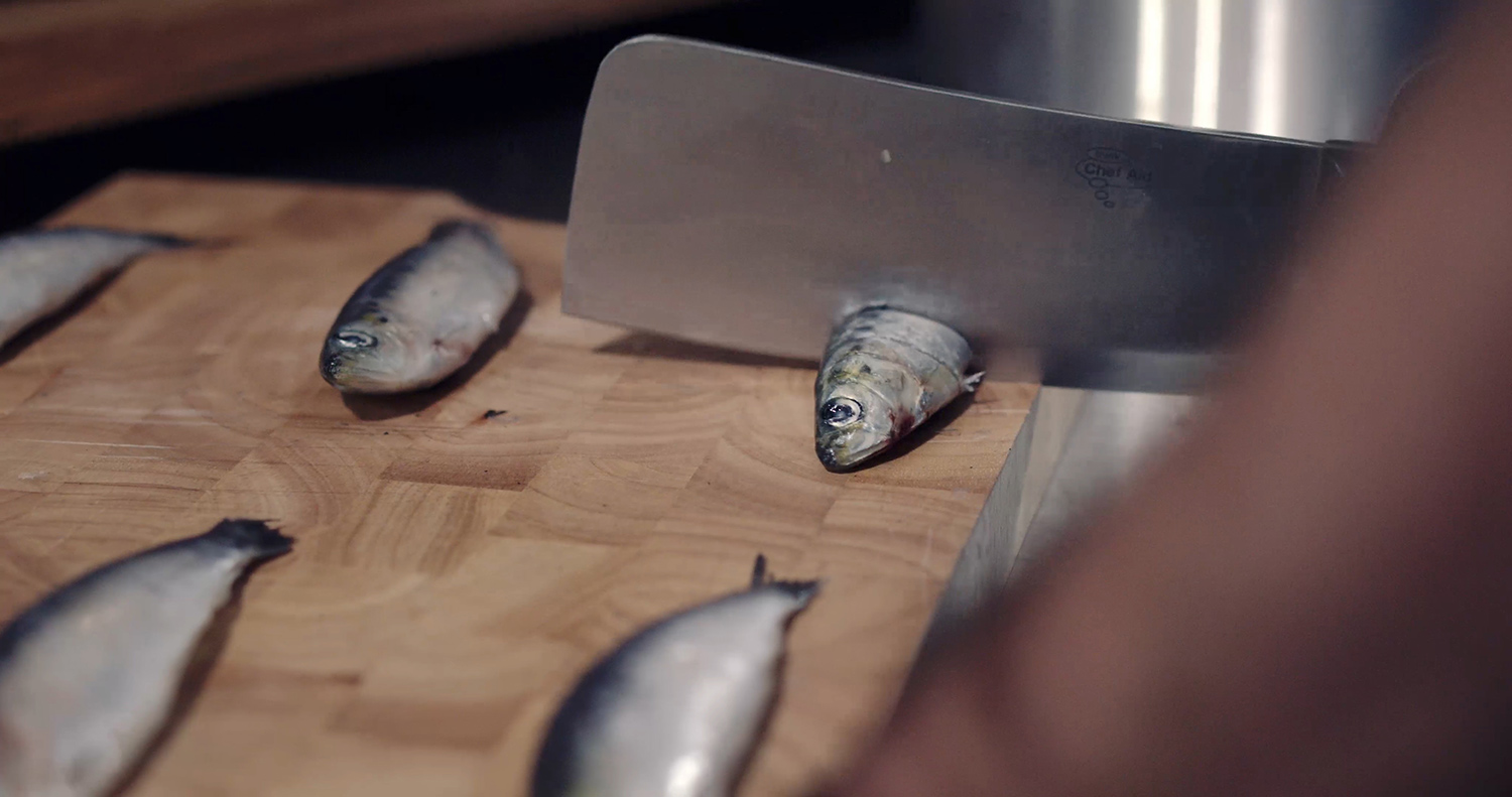 Fish being chopped with a cleaving knife